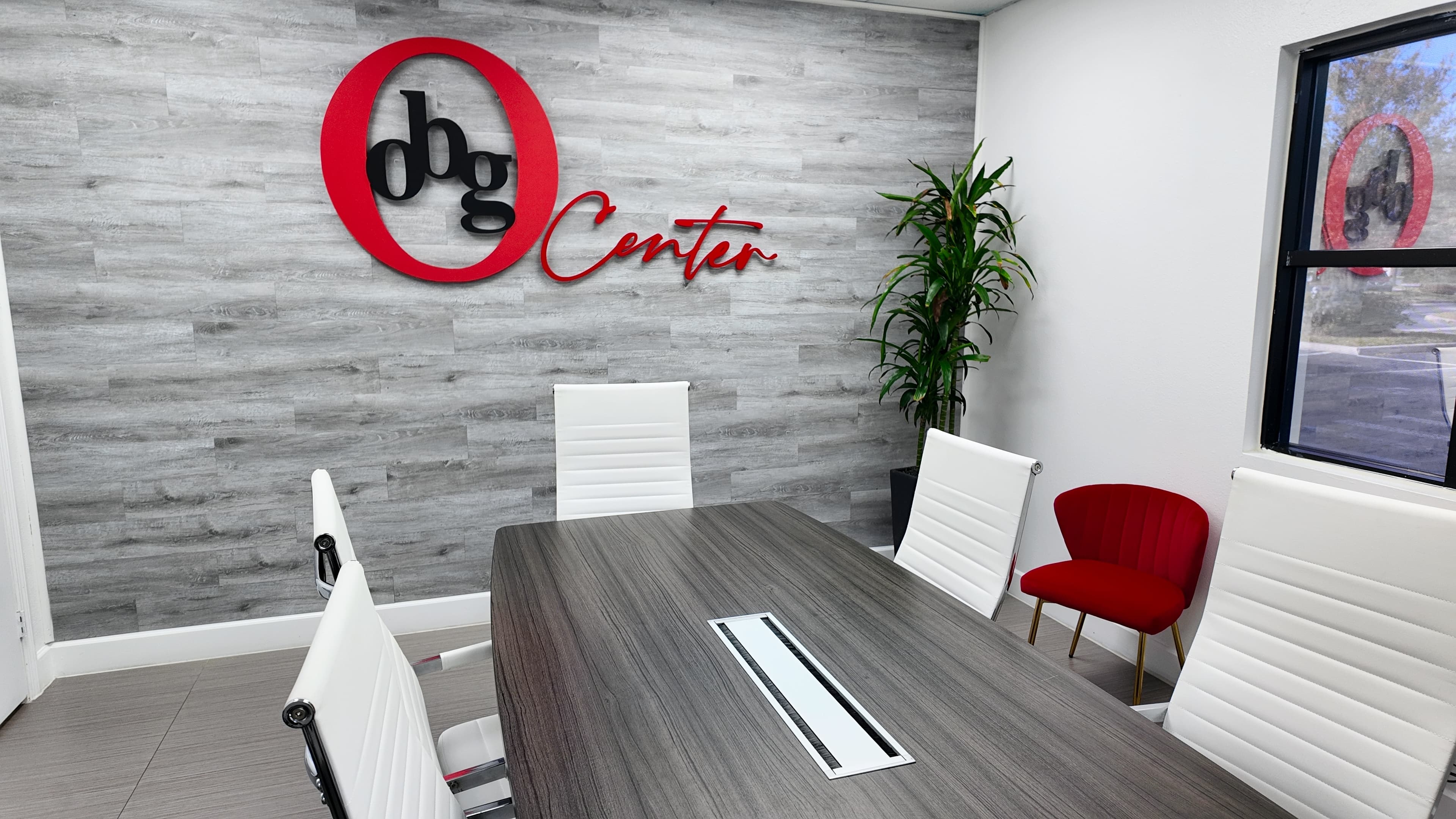 Salón de reuniones real de OBG Center, con mesa corporativa y sillas blancas